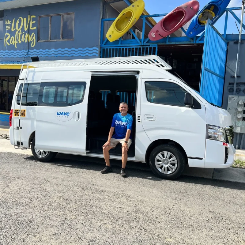 WAVE shuttle parked at rafting center with colorful kayaks in Costa Rica