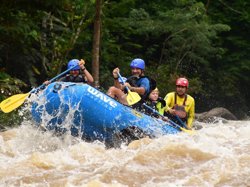 Rafters navigating Class III rapids on an Arenal rafting tour during rainy season