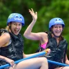 Two happy women enjoying a whitewater rafting tour in Arenal, Costa Rica.