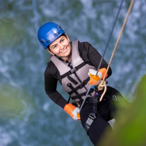 Woman rappelling down a 104-ft tropical waterfall in Rainforest Falls, Costa Rica.